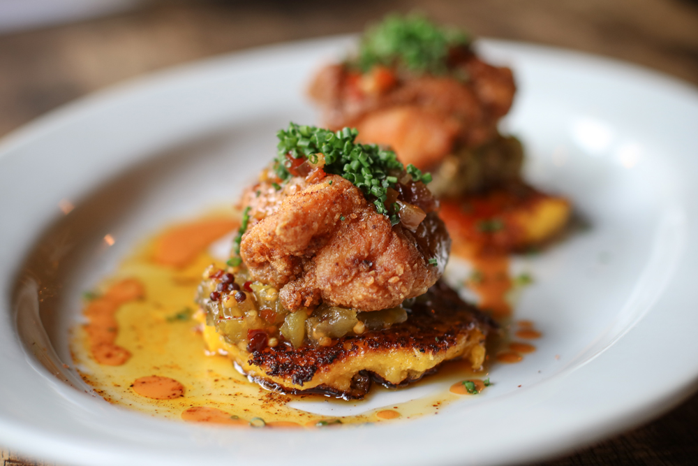 Fried Chicken Pancakes with parmesan corn pancakes served with green tomato chow chow and hot sauce honey. Served at The Local Craft Food & Drink in Coral Gables, Florida