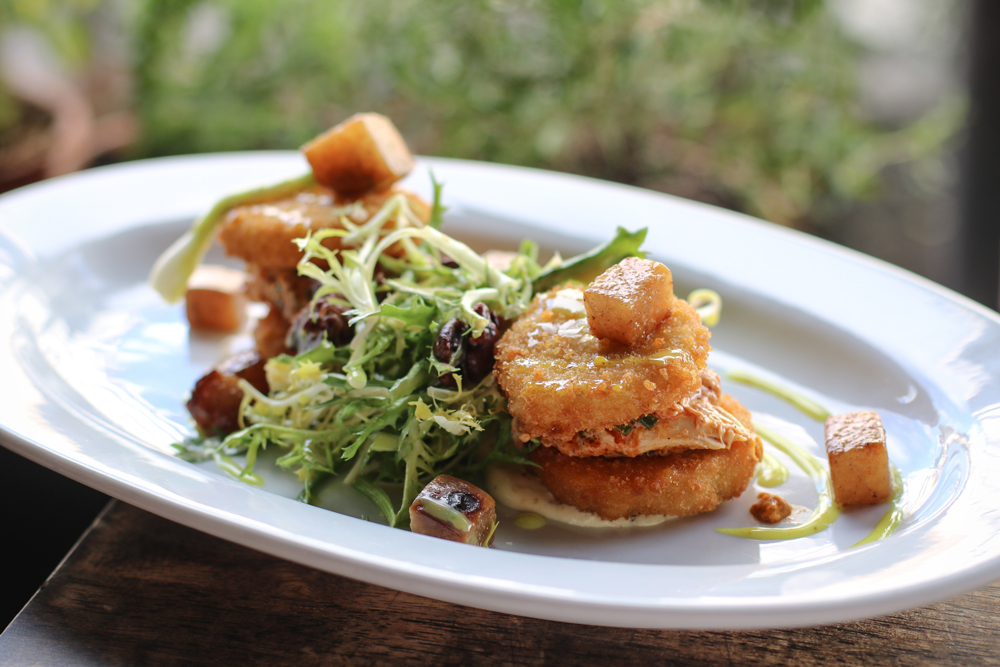 This is the smoked chicken salad at The Local in Coral Gables, Florida. It has fried green tomatoes, mixed greens, pears, pecans, a vinaigrette and smoked chicken of course!