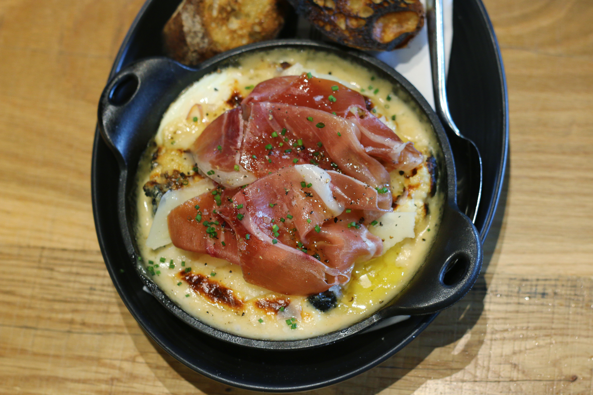 Wood oven baked eggs topped with prosciutto from restaurant Glass & Vine in the Grove. It's AMAZING! Click to read more or pin and save for later! Coral Gables | Miami | Coconut Grove | Florida
